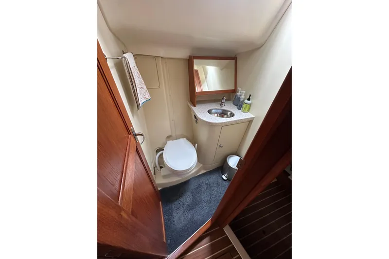 Slide: The Image of Compact bathroom in 2003 Hunter 426 Deck Salon yacht with sink, toilet, and mirror. - 15