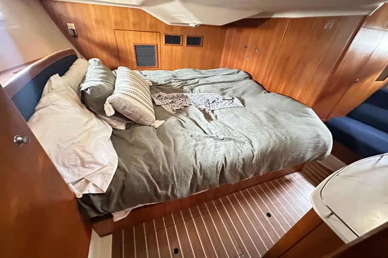 Slide: The Image of Cozy cabin interior of 2003 Hunter 426 Deck Salon with comfortable bedding and wooden paneling. - 16