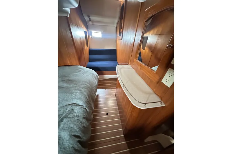 Slide: The Image of 2003 Hunter 426 Deck Salon interior with wood paneling, bed, and small window. - 17