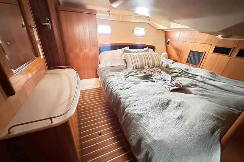 Slide: The Image of Cozy cabin interior of 2003 Hunter 426 Deck Salon with wooden furnishings and comfortable bedding. - 19