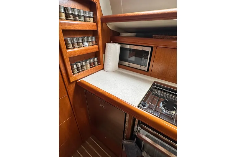 Slide: The Image of Galley kitchen in 2003 Hunter 426 Deck Salon with spice rack and microwave. - 22