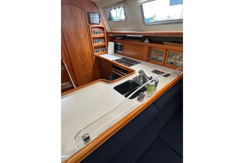 Slide: The Image of Interior of 2003 Hunter 426 Deck Salon yacht kitchen with wooden cabinetry and modern appliances. - 23