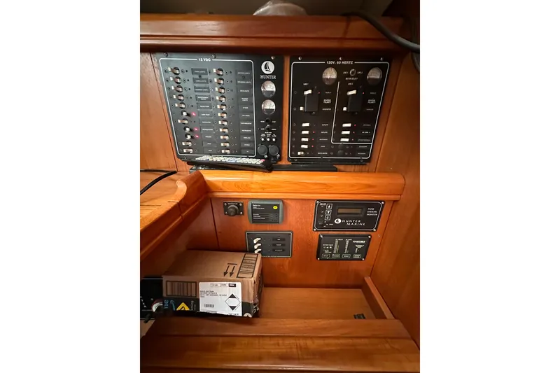 Slide: The Image of Control panel of a 2003 Hunter 426 Deck Salon sailboat, featuring various switches and gauges. - 26