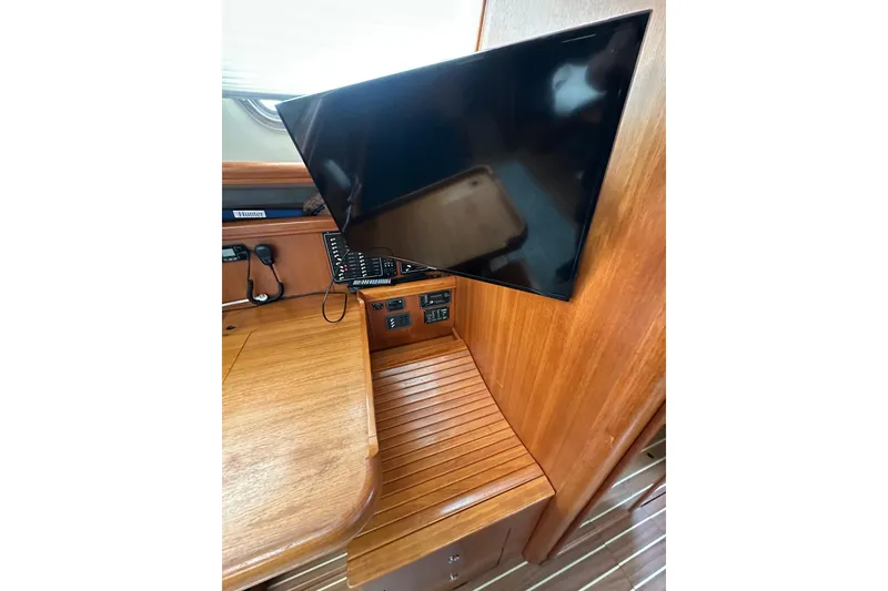 Slide: The Image of Interior of 2003 Hunter 426 Deck Salon with mounted TV and wooden cabinetry. - 27