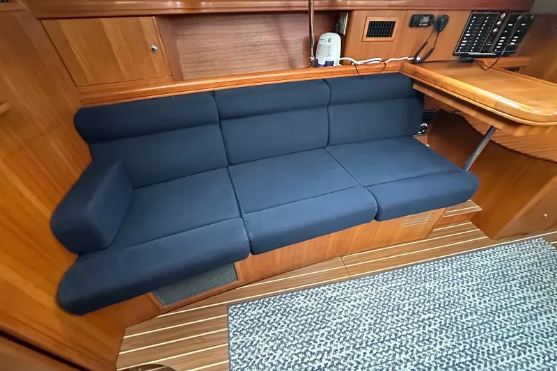 Slide: The Image of Interior of 2003 Hunter 426 Deck Salon with blue cushioned seating and wooden finish. - 28