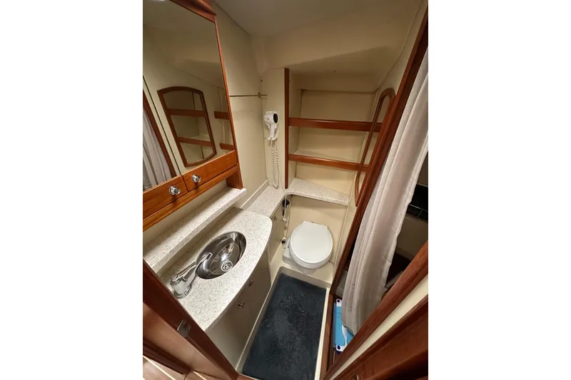 Slide: The Image of Compact bathroom in 2003 Hunter 426 Deck Salon yacht with sink, toilet, and mirror. - 30