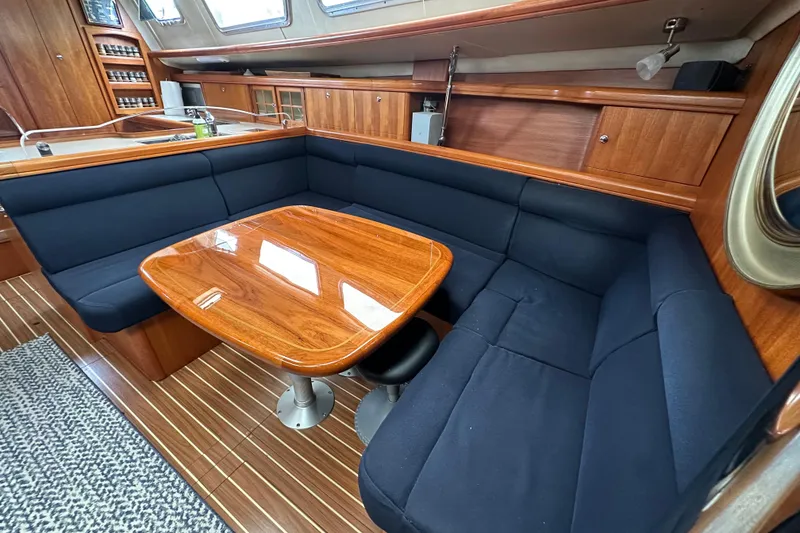 Slide: The Image of Interior of 2003 Hunter 426 Deck Salon with wooden table and navy seating. - 32