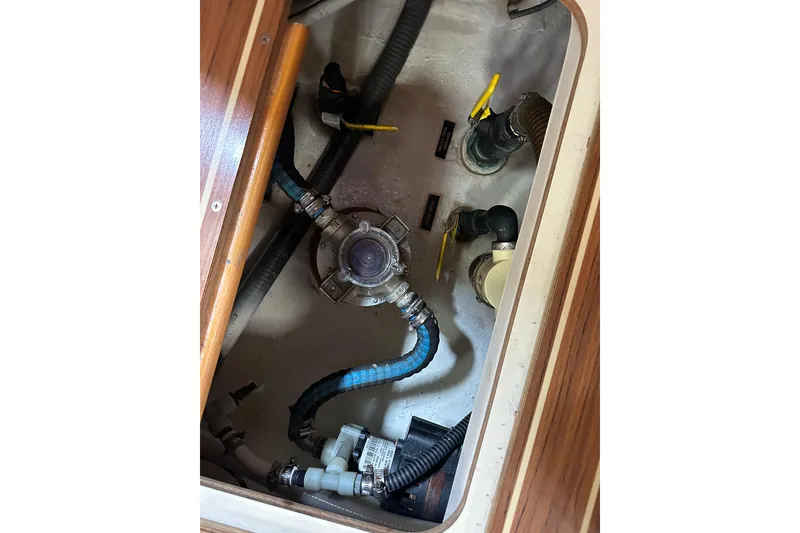 Slide: The Image of Engine compartment of 2003 Hunter 426 Deck Salon sailboat, showing hoses and valves. - 38
