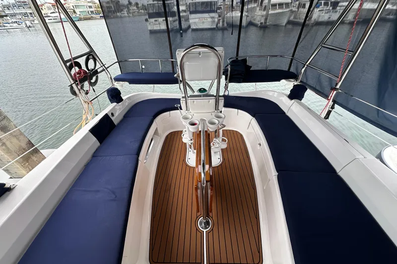 Slide: The Image of Cockpit of 2003 Hunter 426 Deck Salon sailboat with blue seating and wooden flooring. - 40