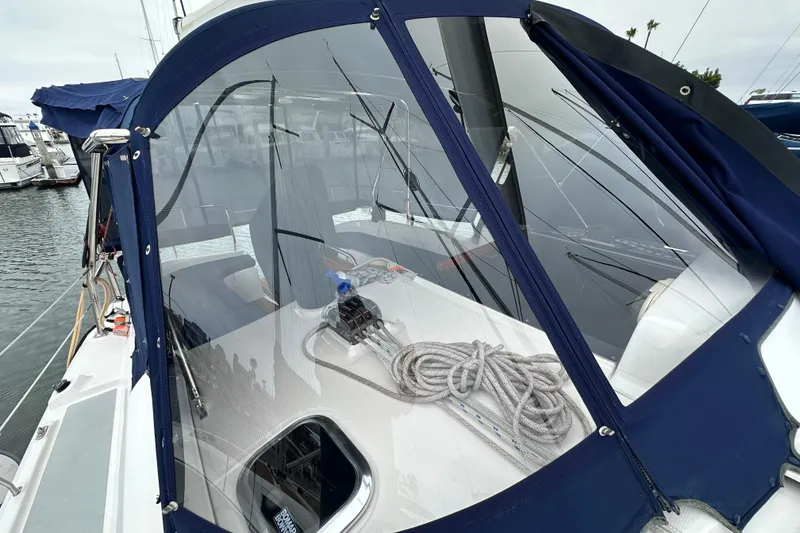 Slide: The Image of 2003 Hunter 426 Deck Salon sailboat with blue canopy and coiled rope on deck. - 8