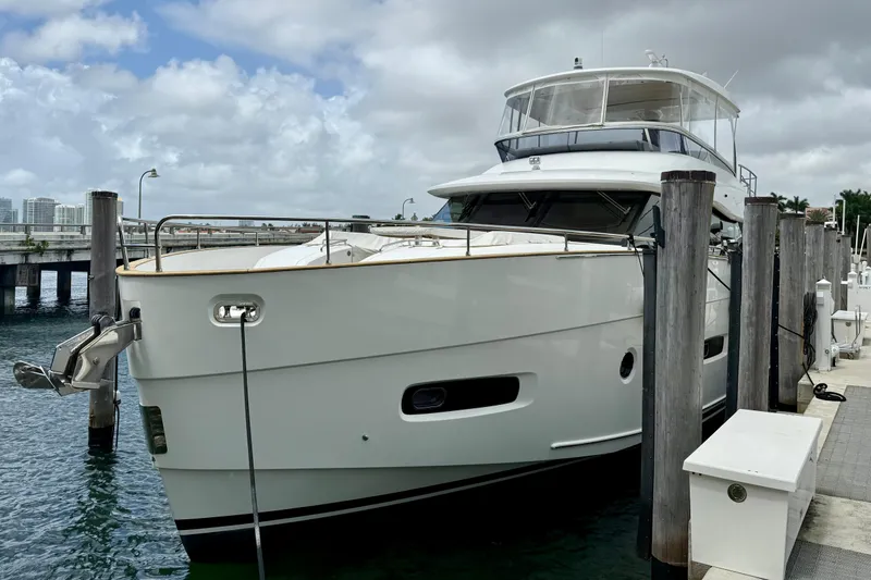 Slide: The Image of Azimut Magellano 66 yacht docked at marina, 2020 model, under cloudy skies. - 2