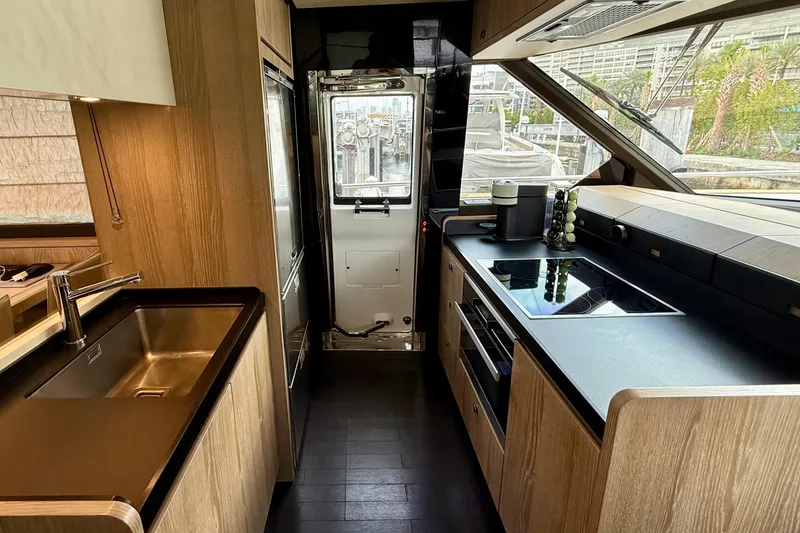 Slide: The Image of Modern kitchen interior of 2020 Azimut Magellano 66 yacht with sleek appliances and wood finishes. - 32