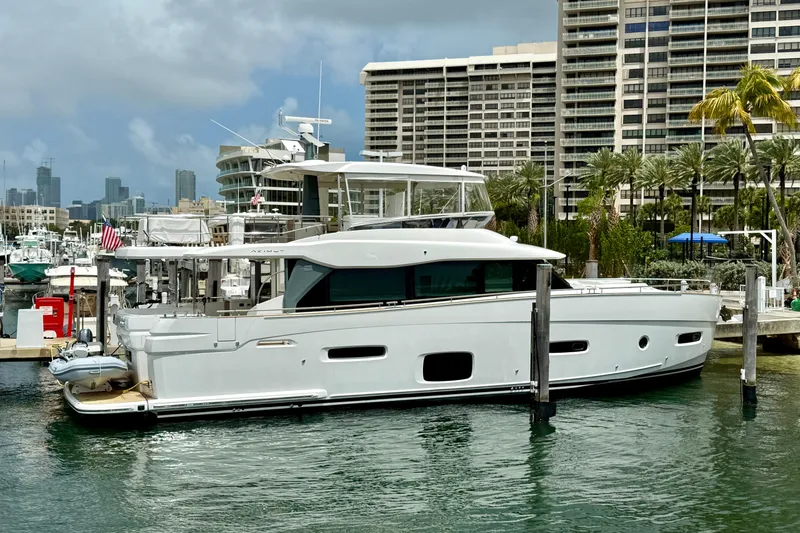 Slide: The Image of Azimut Magellano 66 yacht docked in a marina, 2020 model, with cityscape background. - 4