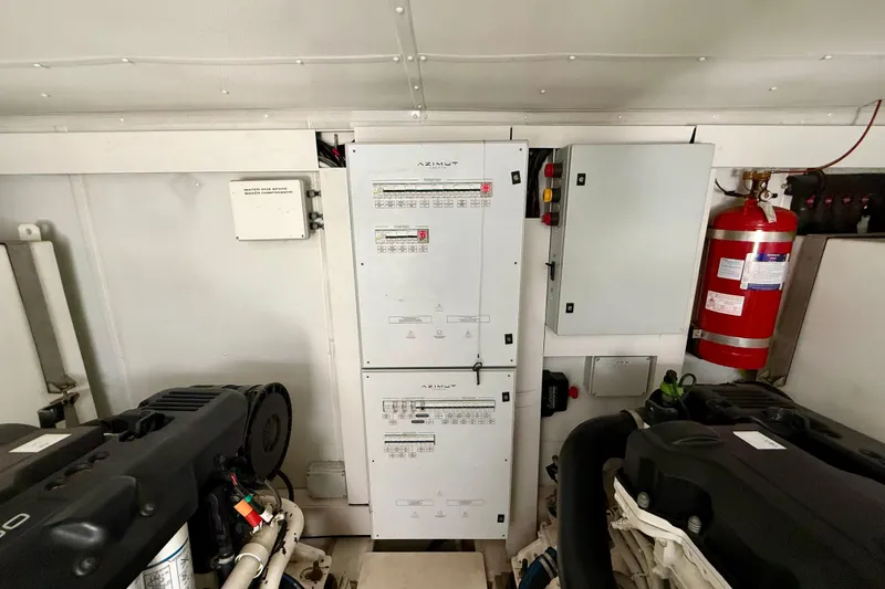 Slide: The Image of Engine room of 2020 Azimut Magellano 66 yacht with control panels and fire extinguisher. - 87