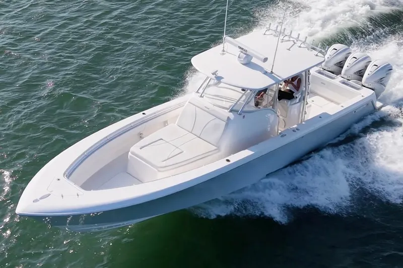 The Image of 2021 Contender 39 Fisharound boat cruising on open water with triple engines. - 1