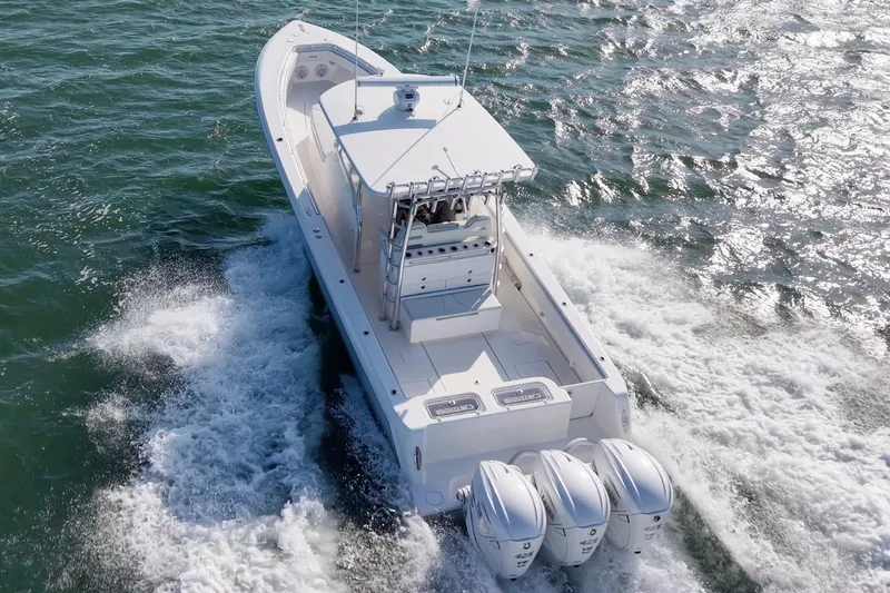 Slide: The Image of 2021 Contender 39 Fisharound boat cruising on open water with triple outboard engines. - 11