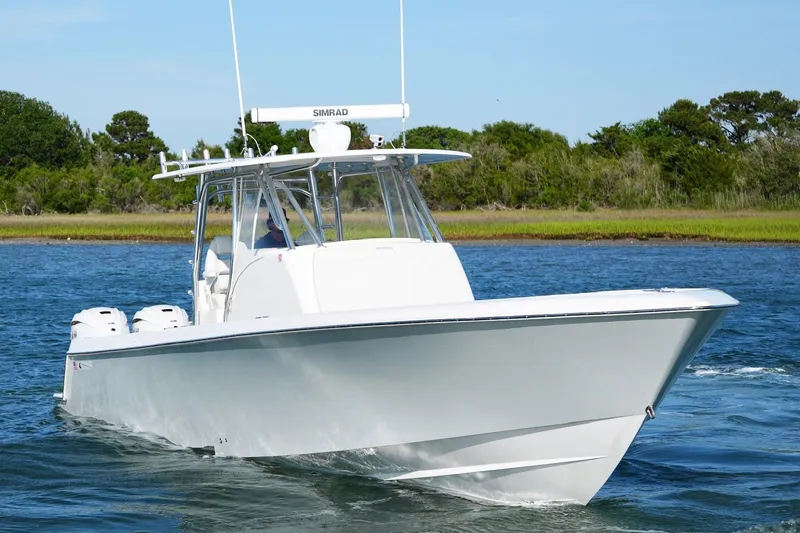 Slide: The Image of 2021 Contender 39 Fisharound boat cruising on a serene waterway. - 6