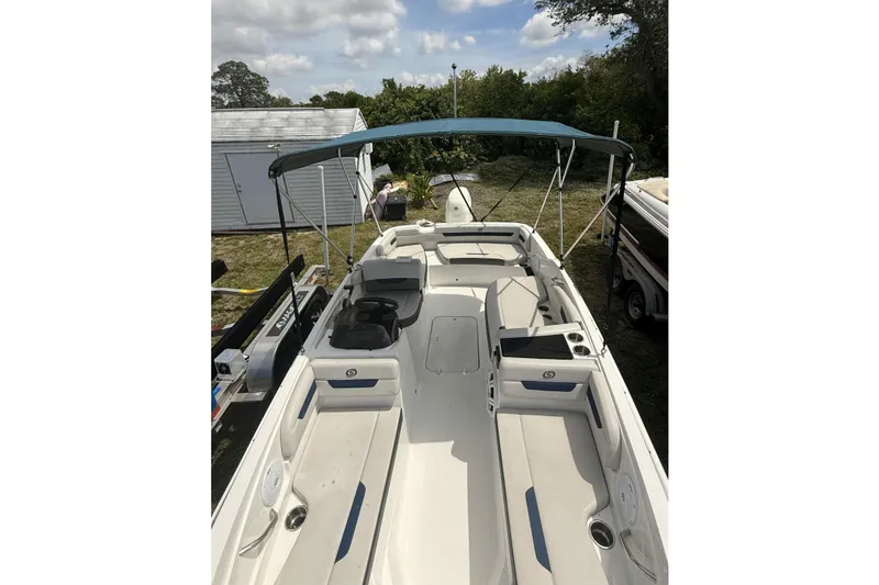 Slide: The Image of 2020 Hurricane SunDeck Sport 185 OB boat with canopy, parked outdoors. - 18
