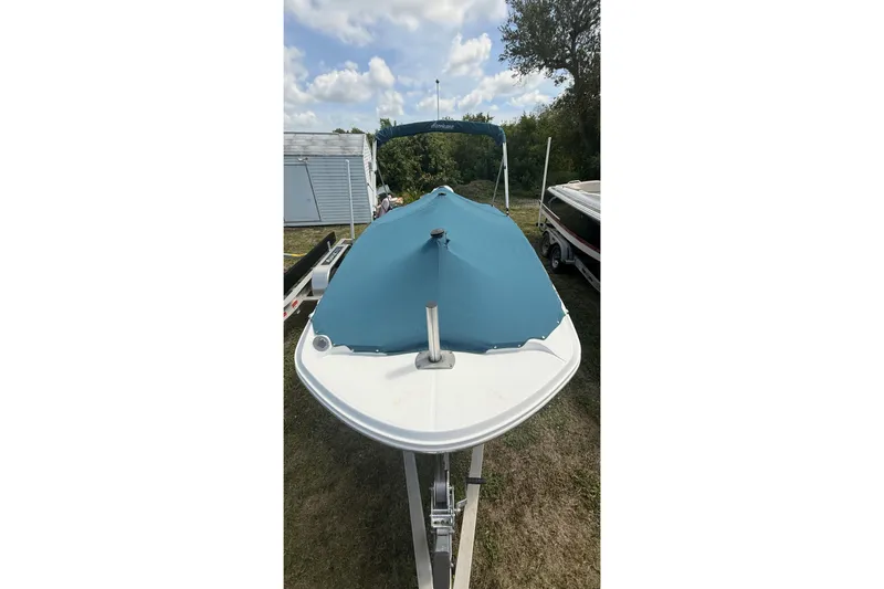 Slide: The Image of 2020 Hurricane SunDeck Sport 185 OB boat with blue cover on trailer, outdoors. - 24