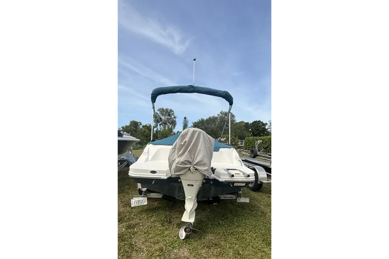 Slide: The Image of 2020 Hurricane SunDeck Sport 185 OB boat with canopy, parked on grass under blue sky. - 26