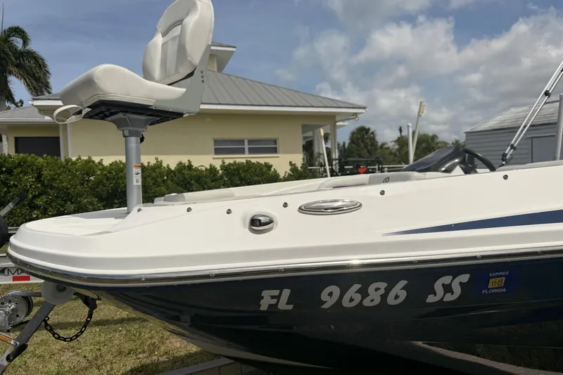 Slide: The Image of 2020 Hurricane SunDeck Sport 185 OB boat with Florida registration, parked near a house. - 3