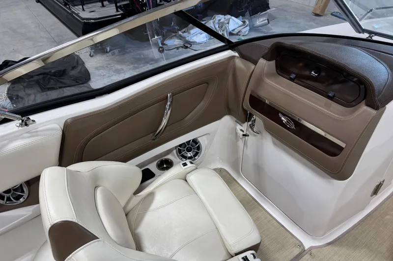 Slide: The Image of Interior of a 2015 Chaparral 257 SSX boat, featuring beige and white seating. - 10