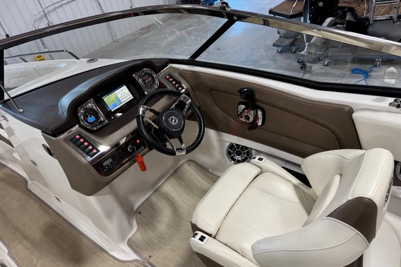 Slide: The Image of 2015 Chaparral 257 SSX boat interior with steering wheel, dashboard, and leather seating. - 11