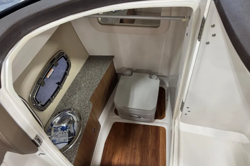 Slide: The Image of Interior of 2015 Chaparral 257 SSX boat with compact toilet and storage area. - 12