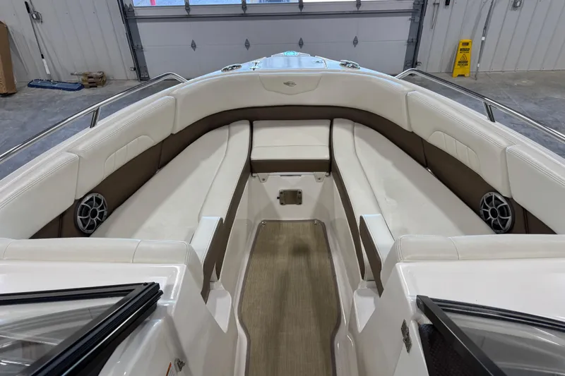 Slide: The Image of 2015 Chaparral 257 SSX boat interior with white and brown seating, speakers, and wood flooring. - 9