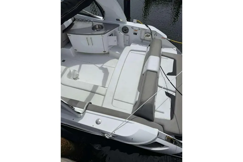 Slide: The Image of 2022 Four Winns H290 OB boat interior with seating and kitchenette area. - 12
