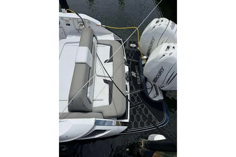 Slide: The Image of 2022 Four Winns H290 OB boat with dual Mercury outboard engines and spacious seating. - 15