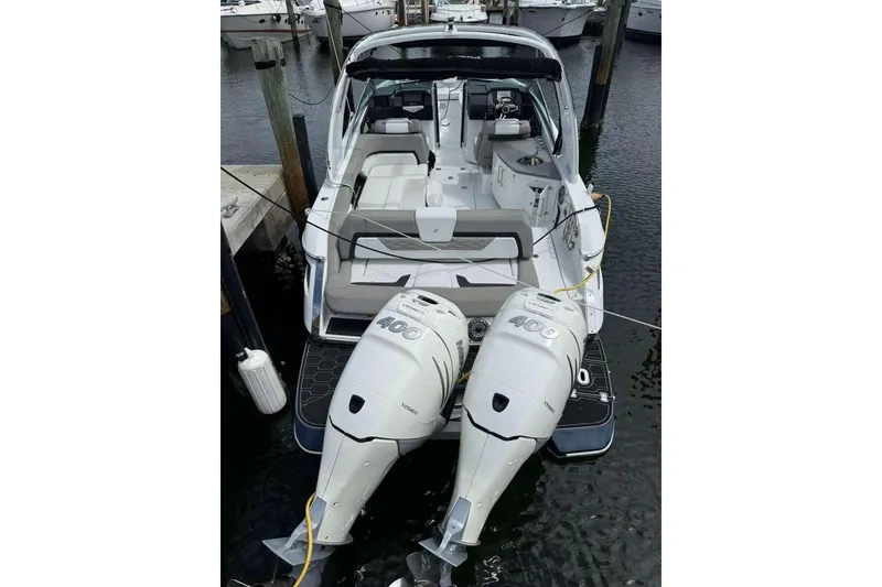 Slide: The Image of 2022 Four Winns H290 OB boat with dual 400 horsepower outboard engines docked at marina. - 19
