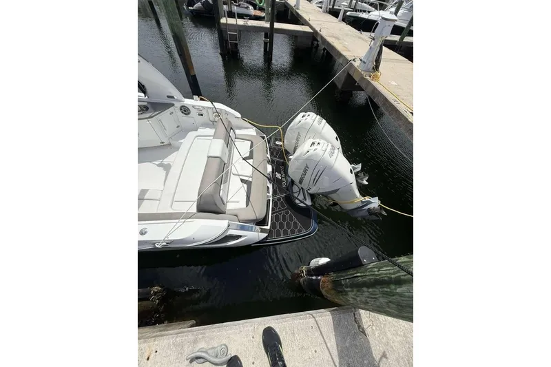 Slide: The Image of 2022 Four Winns H290 OB boat docked with twin outboard engines. - 2