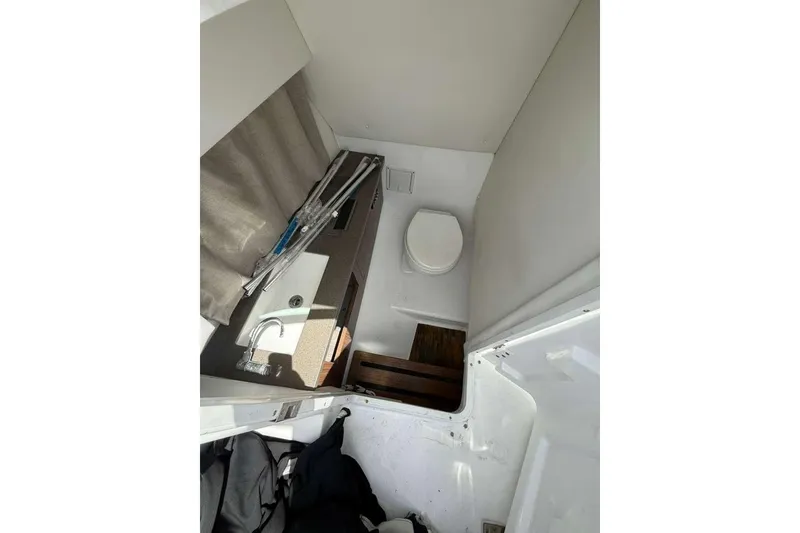 Slide: The Image of Interior of 2022 Four Winns H290 OB boat featuring compact bathroom amenities. - 5
