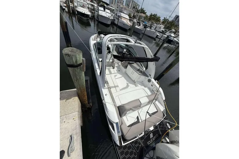 Slide: The Image of 2022 Four Winns H290 OB boat docked at marina, featuring spacious seating and modern design. - 9