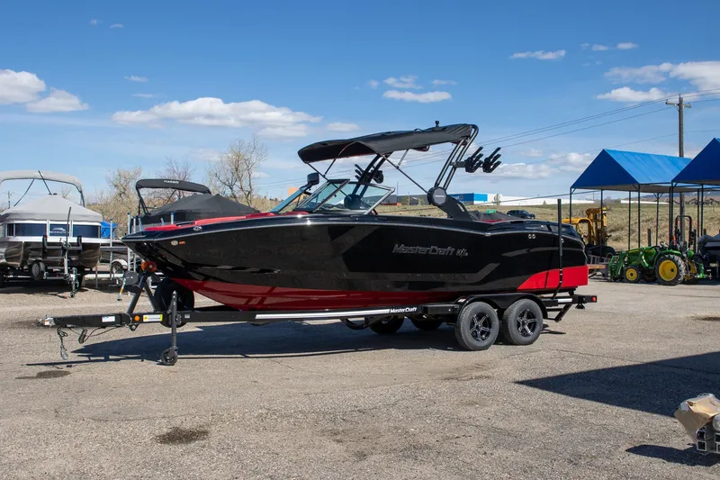 The Image of 2024 MasterCraft NXT23 boat on trailer outdoors. - 1