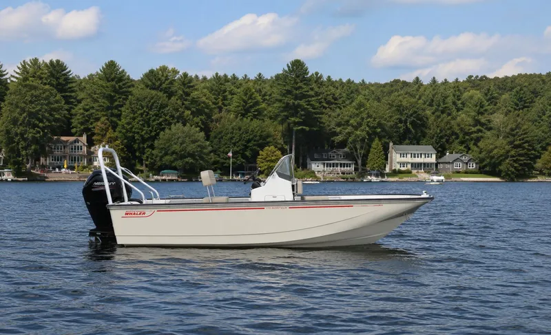 The Image of Boston Whaler 170 Montauk 2026 on a serene lake with wooded backdrop. - 1