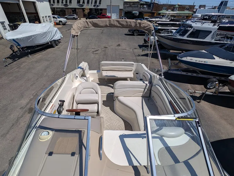 Slide: The Image of 2007 Larson Cabrio 240 boat interior view in a parking lot. - 11