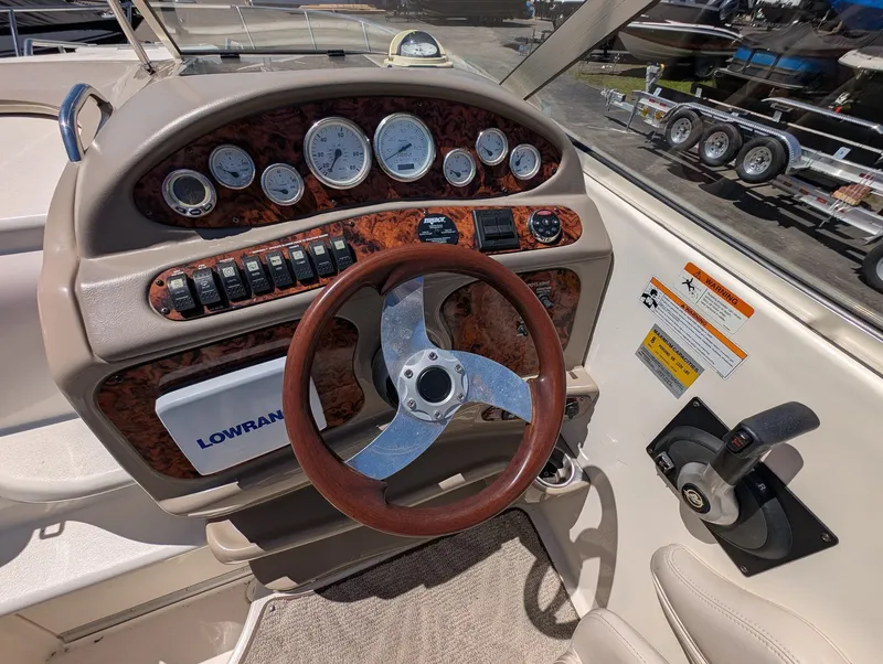Slide: The Image of 2007 Larson Cabrio 240 boat helm with wood paneling and gauges. - 14