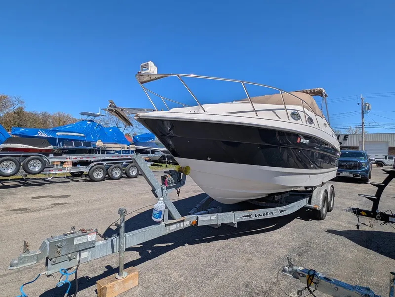 Slide: The Image of 2007 Larson Cabrio 240 boat on trailer outdoors. - 2