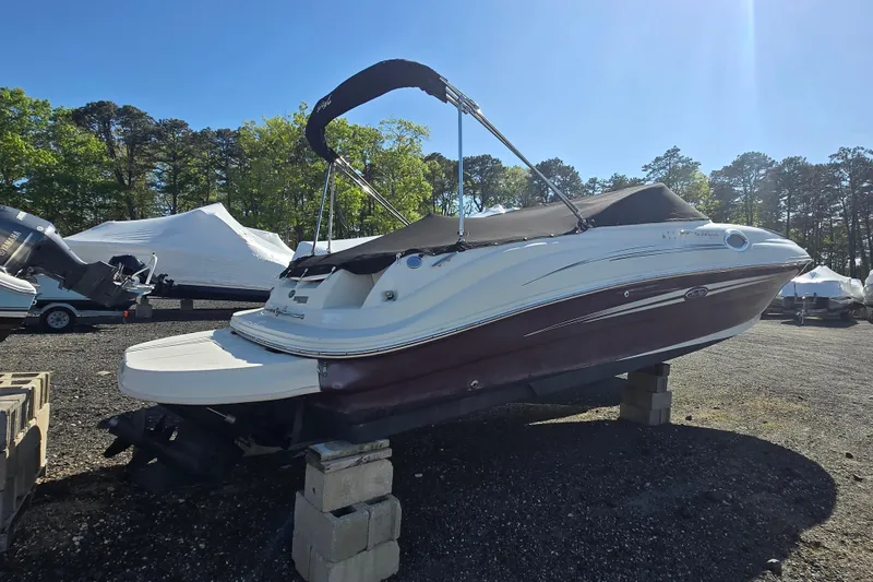 The Image of 2009 Sea Ray 240 Sundeck boat on blocks, outdoor storage, sunny day. - 0