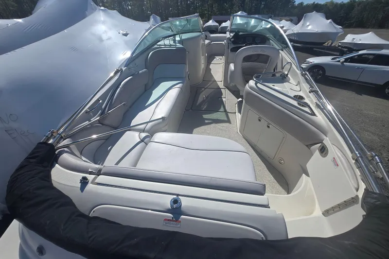 Slide: The Image of 2009 Sea Ray 240 Sundeck boat interior with seating and dashboard, parked outdoors. - 1
