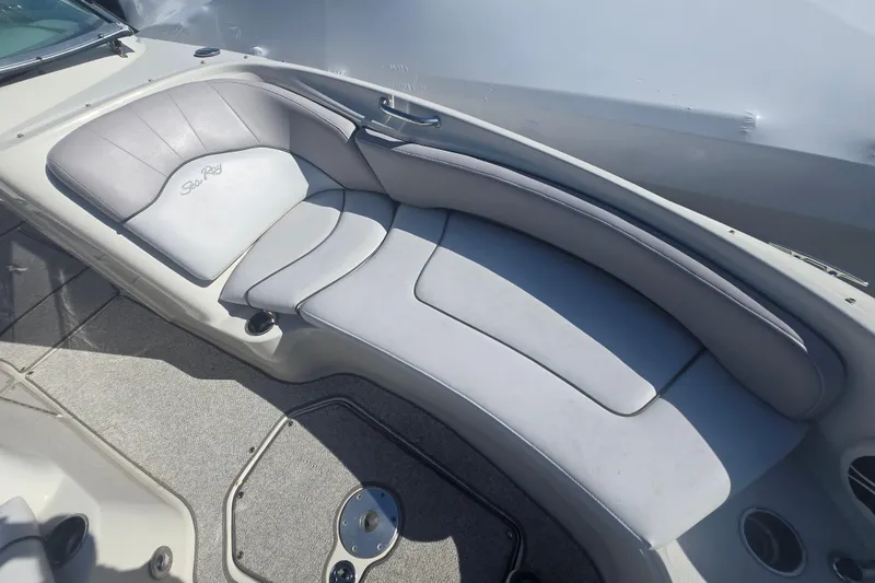 Slide: The Image of 2009 Sea Ray 240 Sundeck boat interior with cushioned seating and sleek design. - 10