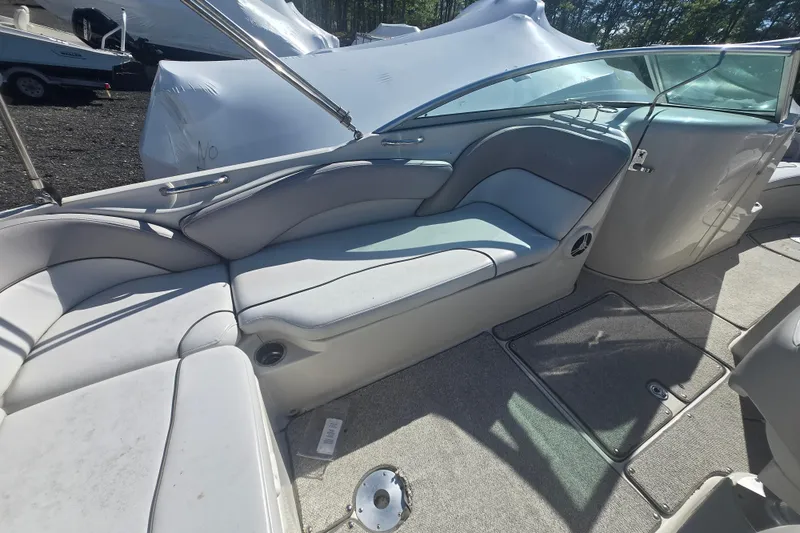 Slide: The Image of 2009 Sea Ray 240 Sundeck interior with cushioned seating and carpeted flooring. - 13