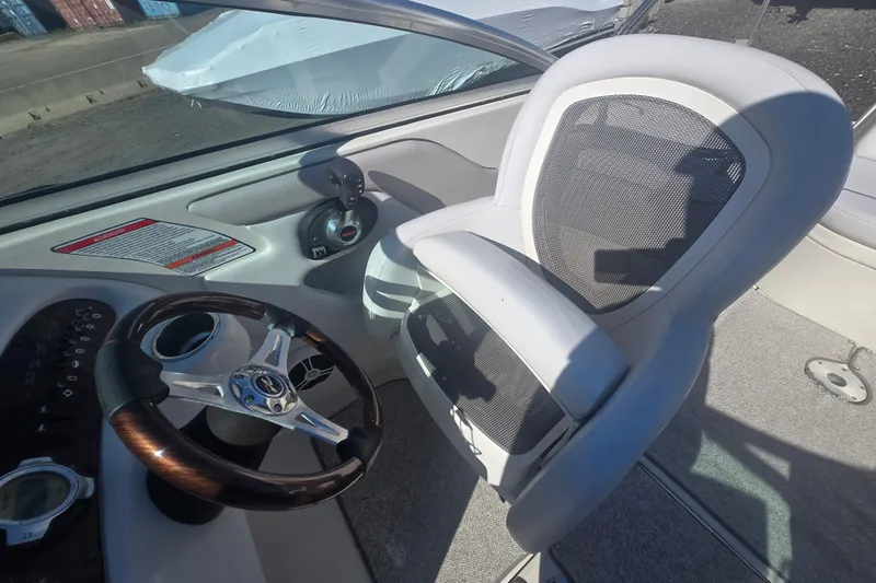 Slide: The Image of 2009 Sea Ray 240 Sundeck cockpit with steering wheel and captain's chair. - 15
