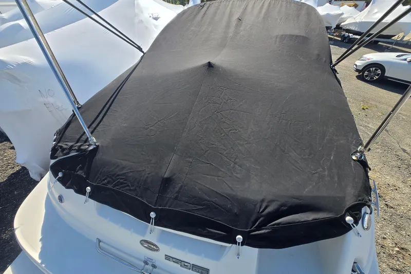 Slide: The Image of 2009 Sea Ray 240 Sundeck with black cover in storage yard. - 17