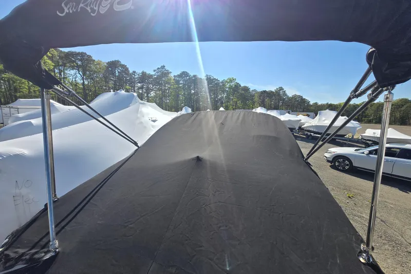 Slide: The Image of 2009 Sea Ray 240 Sundeck with black canopy in a sunny outdoor setting. - 19