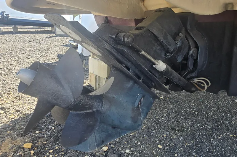 Slide: The Image of 2009 Sea Ray 240 Sundeck boat propeller and drive system on gravel surface. - 21
