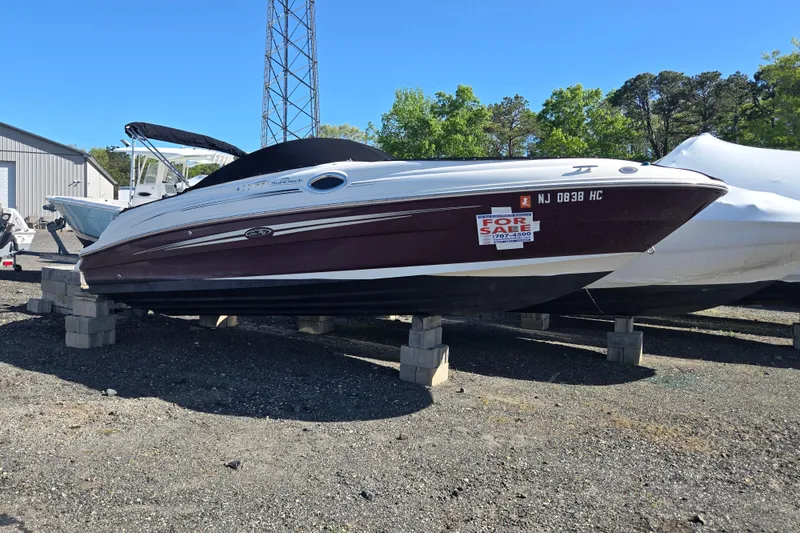 Slide: The Image of 2009 Sea Ray 240 Sundeck boat for sale, displayed on blocks outdoors. - 6