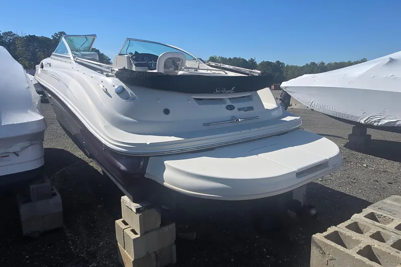 Slide: The Image of 2009 Sea Ray 240 Sundeck boat on blocks, outdoor storage, clear sky background. - 8